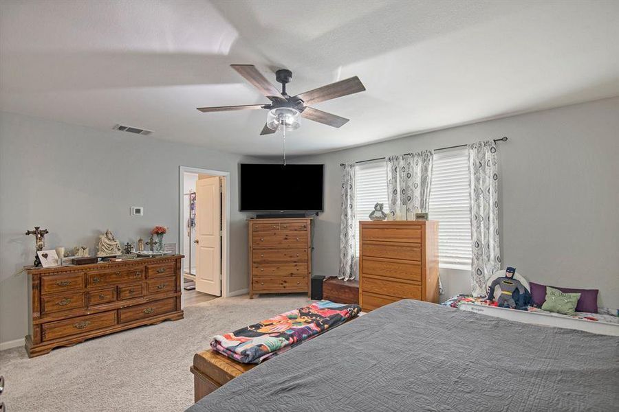 Carpeted bedroom featuring ceiling fan