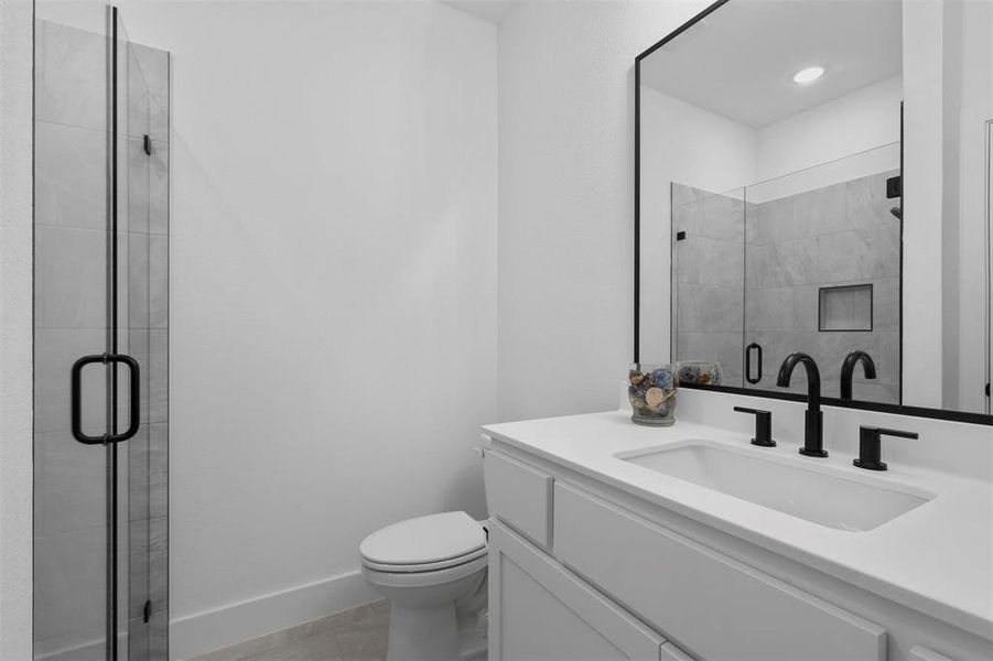 Bathroom with tile patterned flooring, vanity, toilet, and a shower with shower door