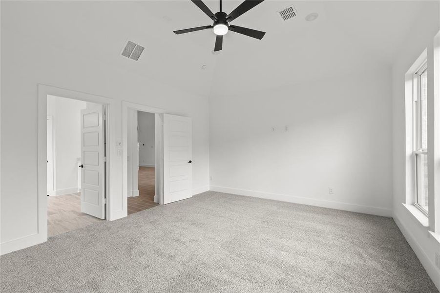 Unfurnished bedroom with ceiling fan, high vaulted ceiling, and light colored carpet