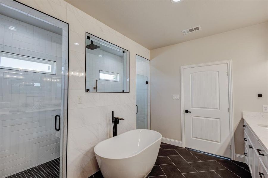 Bathroom featuring vanity, tile walls, independent shower and bath, and tile patterned floors