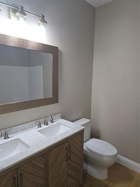 Bathroom with hardwood / wood-style floors, vanity, and toilet