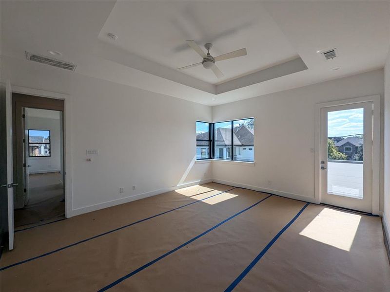 Master bedroom with balcony and corner windows.