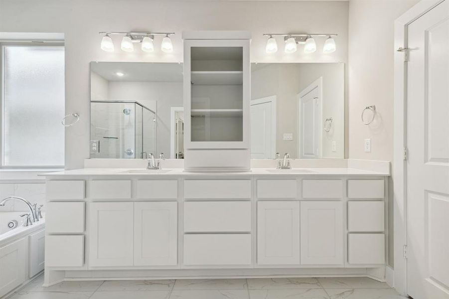 Bathroom with tile floors, double sink vanity, and independent shower and bath