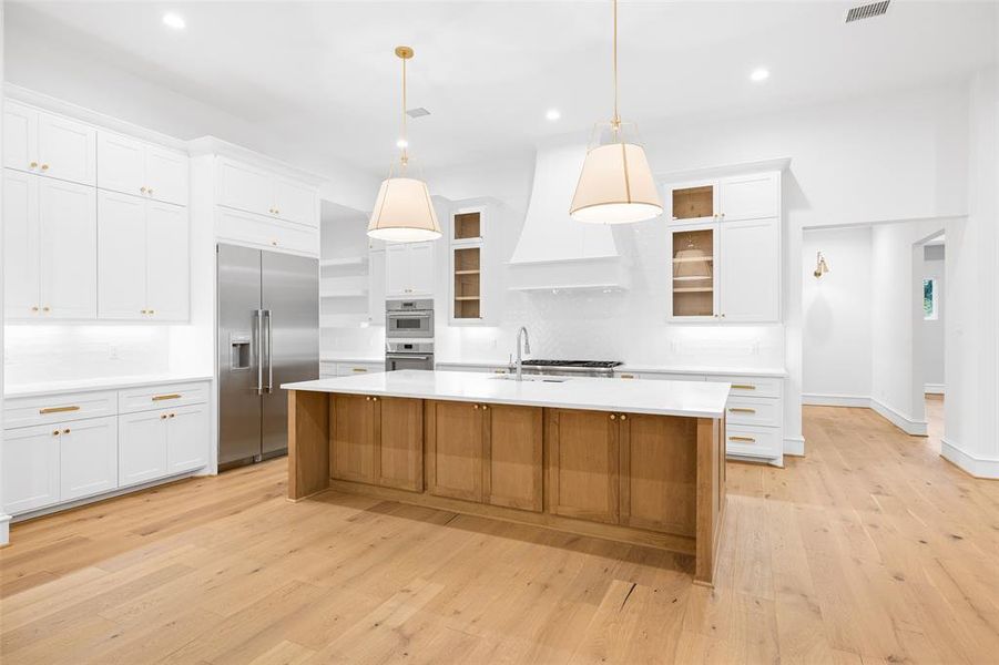 This Kitchen is a dream with a 10 foot island, custom cabinetry, quartz countertops, Rejuvenation hardware and Thermador appliances, including a 48 inch range, an additional oven and microwave.