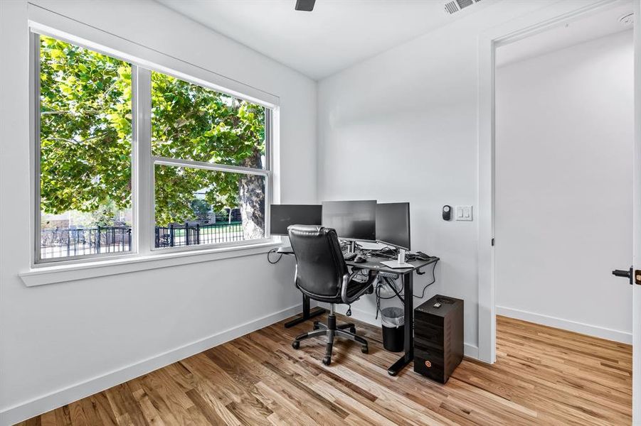 Home office featuring light hardwood floors and bathroom with shower and vanity