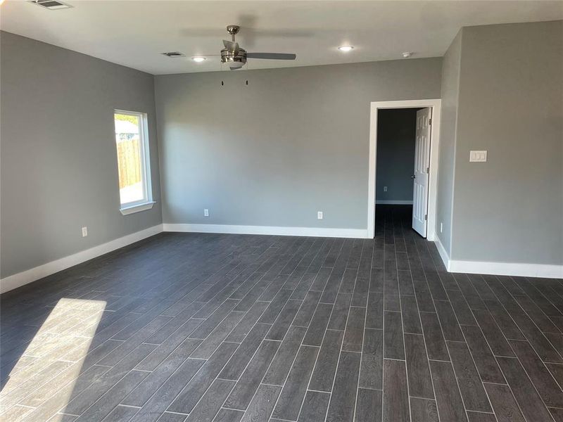 Empty room featuring dark hardwood / wood-style floors and ceiling fan