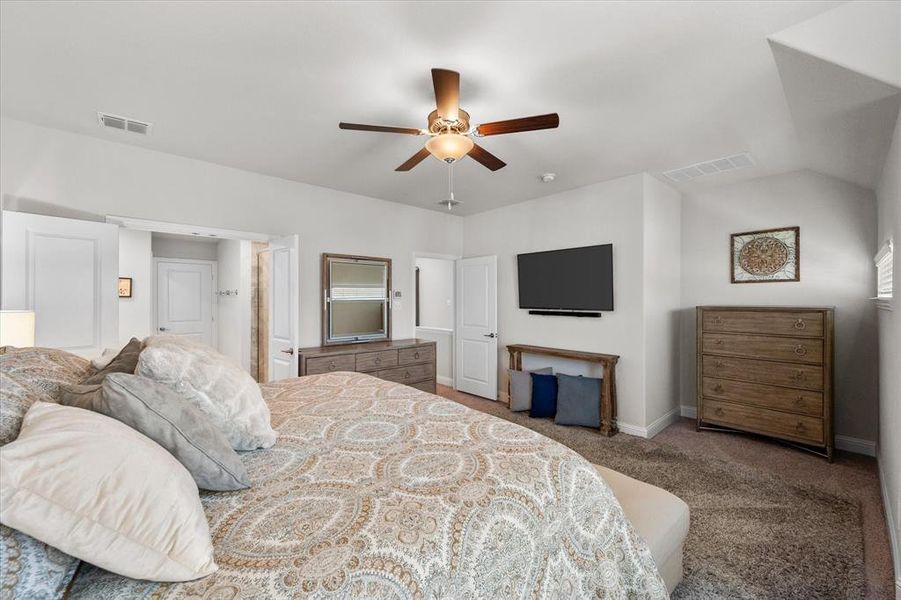 Bedroom featuring vaulted ceiling, ceiling fan, and carpet floors