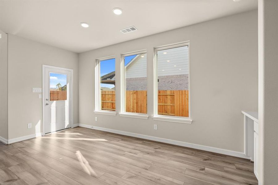 With an abundance of natural light streaming through the windows, the breakfast nook is bathed in a sunny glow, creating the perfect atmosphere to enjoy your morning coffee or a family breakfast.