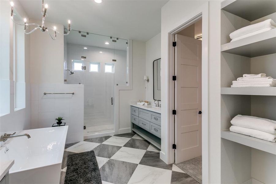 Bathroom with tile floors, a shower with shower door, vanity, and a notable chandelier