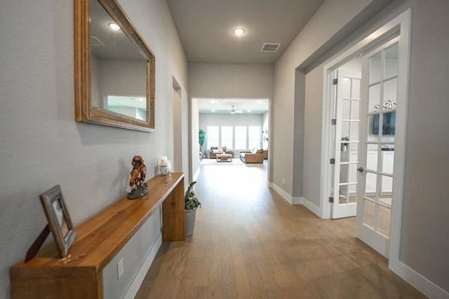 Corridor featuring french doors and hardwood / wood-style flooring