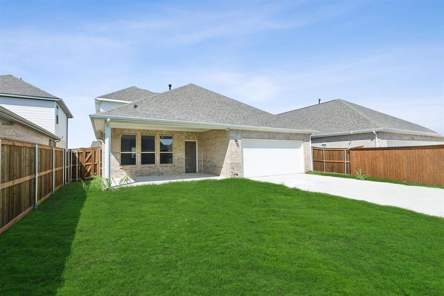 Back of house featuring a yard and a garage