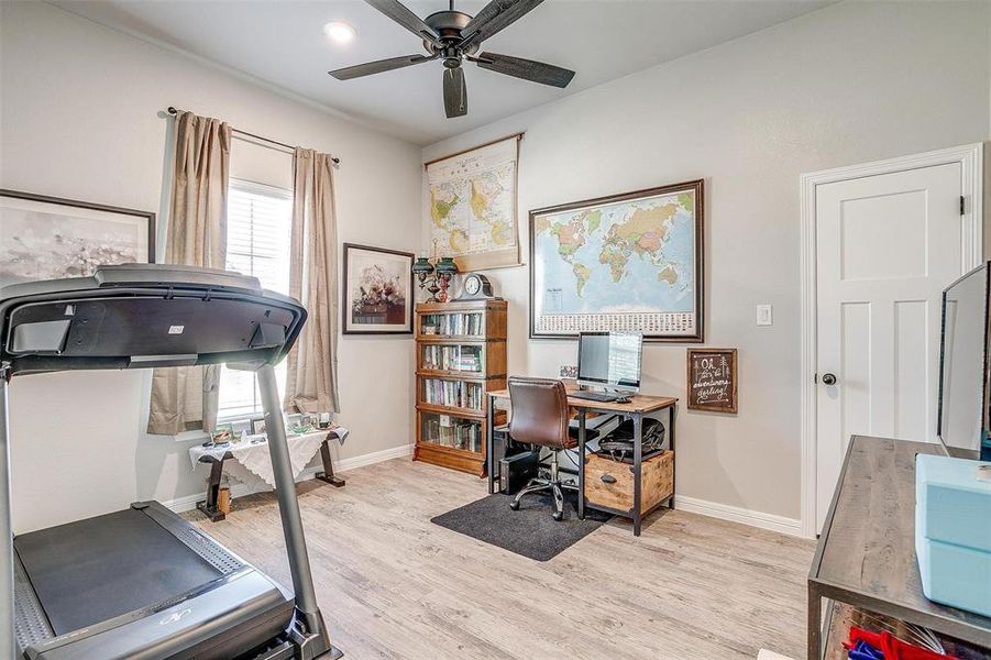 Office with light hardwood / wood-style flooring and ceiling fan