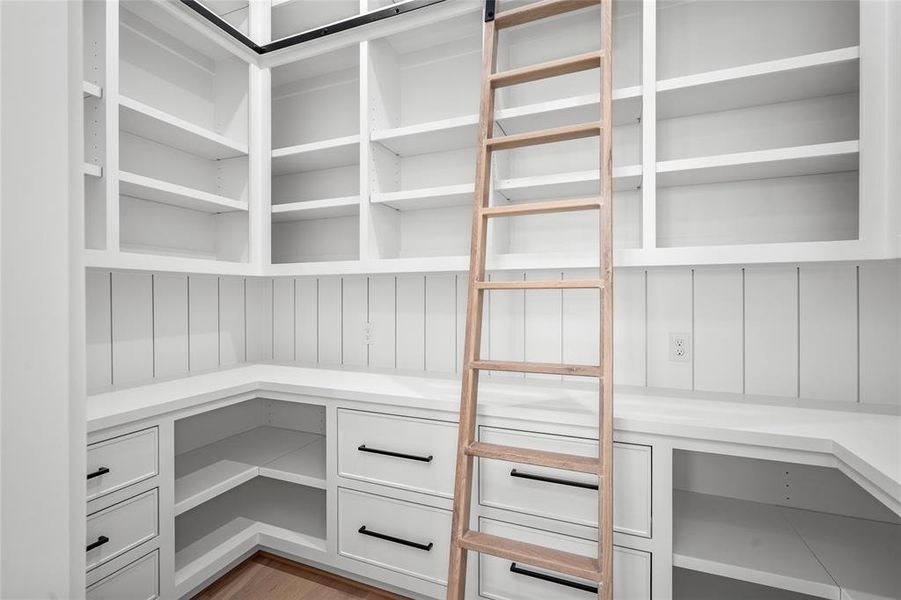 A favorite feature of mine is the huge walk-in pantry that includes counter space for kitchen appliances, outlets and a custom built ladder to provide access to storage out of reach. The slots on the right and left are perfect for lazy susans if you so choose!