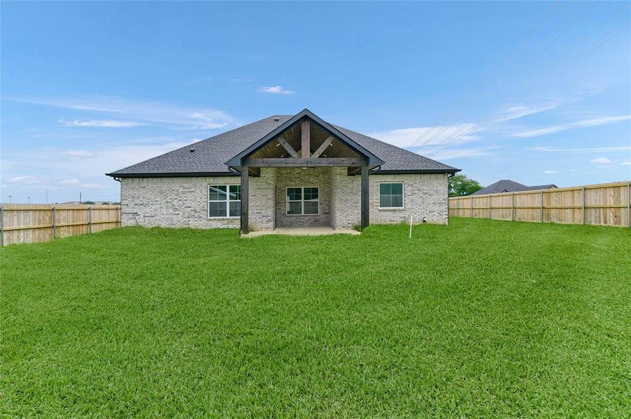 Rear view of house featuring a lawn