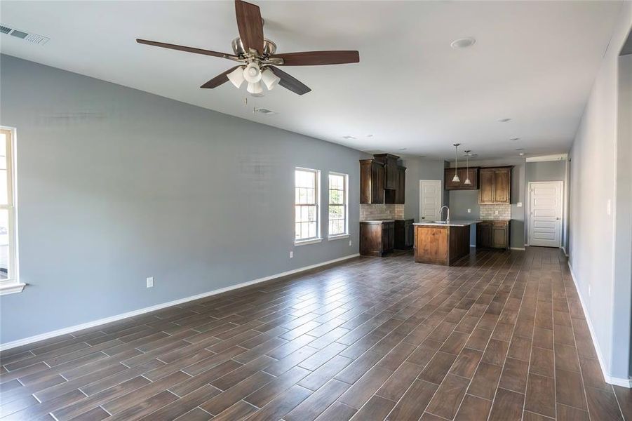 Kitchen featuring decorative backsplash, a center island, dark hardwood / wood-style floors, sink, and pendant lighting