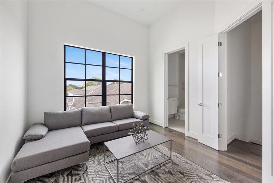 This secondary bedroom, located down the hall from the primary suite, features large windows, an en suite bathroom, and a large closet.