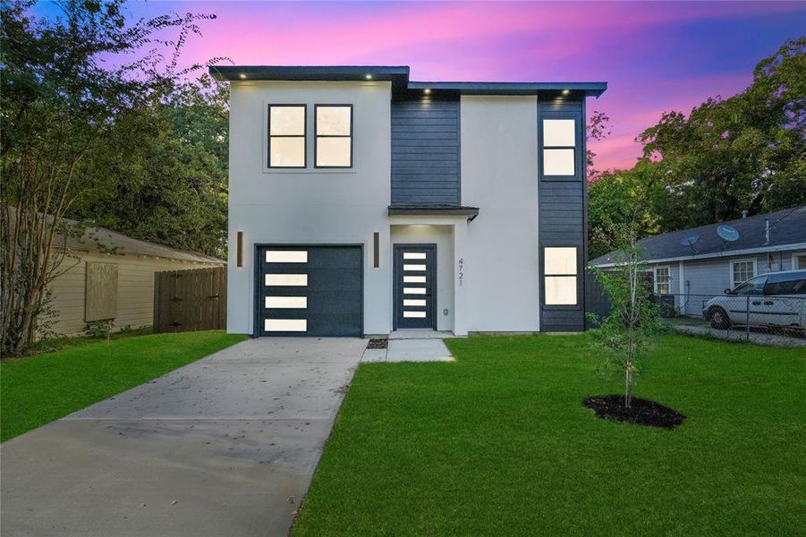 Modern home with a garage and a lawn