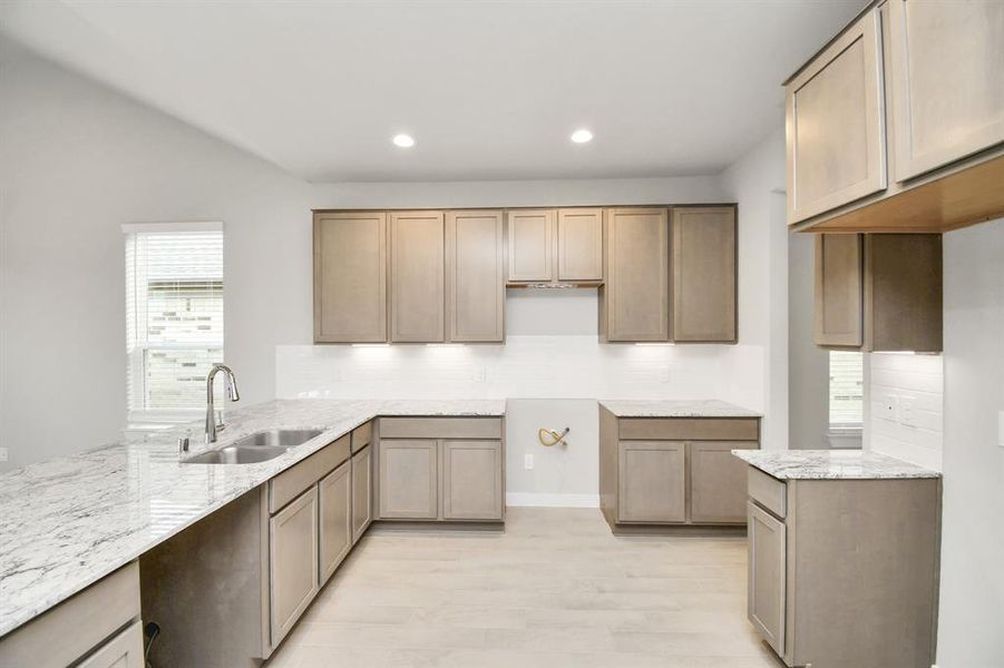 This kitchen is by far any chef’s dream! This spacious kitchen features high ceilings, dark stained wood cabinets, granite countertop, SS appliances (To be Installed), modern tile backsplash, recessed lighting, extended counter space and all overlooking your huge family room. Sample photo of completed home with similar floor plan. Actual colors and selections may vary.