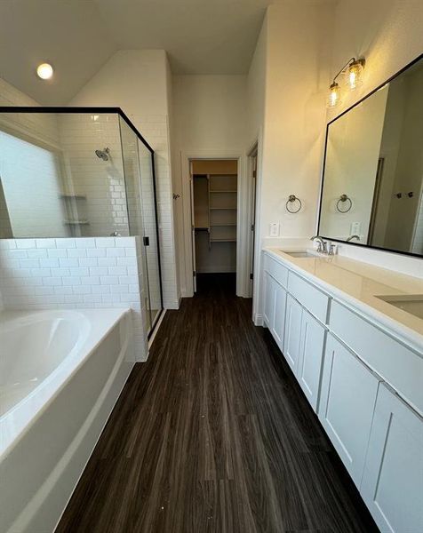 Bathroom featuring hardwood / wood-style floors, independent shower and bath, and vanity