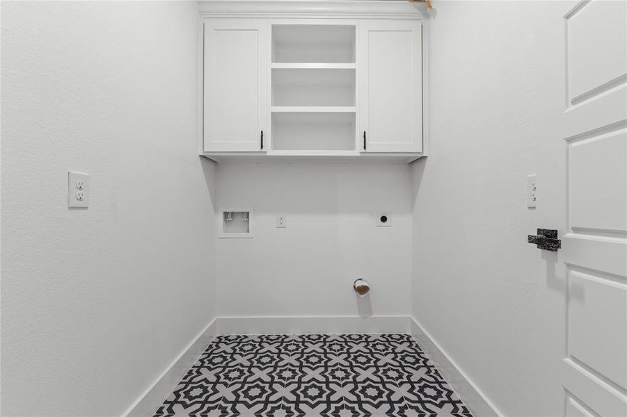 Laundry room with hookup for a washing machine, electric dryer hookup, tile patterned floors, and cabinets