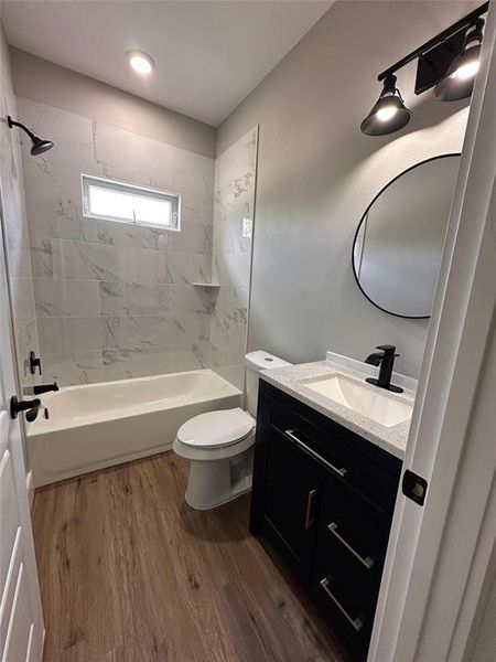 Full secondary bathroom with an oversized vanity, and cute round mirror. Shower and bathtub.