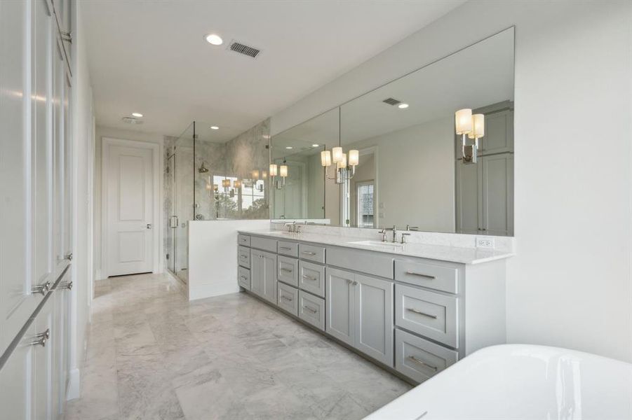 Primary bathroom with independent shower and bath, vanity, and an inviting chandelier