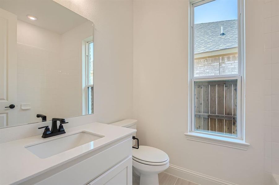 Bathroom featuring toilet, a wealth of natural light, and vanity