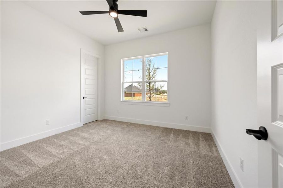 Unfurnished room with light colored carpet and ceiling fan