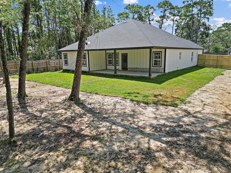 The property includes thoughtfully designed outdoor living areas, such as a large covered patio, perfect for entertaining or relaxing in the shade of the mature trees. These spaces are ideal for enjoying alfresco dining, outdoor gatherings, or simply unwinding in a serene setting.