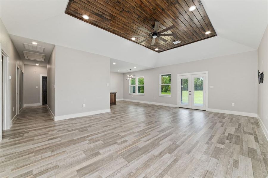 This view highlights the seamless connectivity throughout the home's layout, accentuated by multiple windows and glass double doors that lead to the backyard, filling the space with ample natural sunlight. Whether you're in the kitchen, outdoors, or relaxing in the living room, you'll always feel a sense of connection and flow throughout the home.