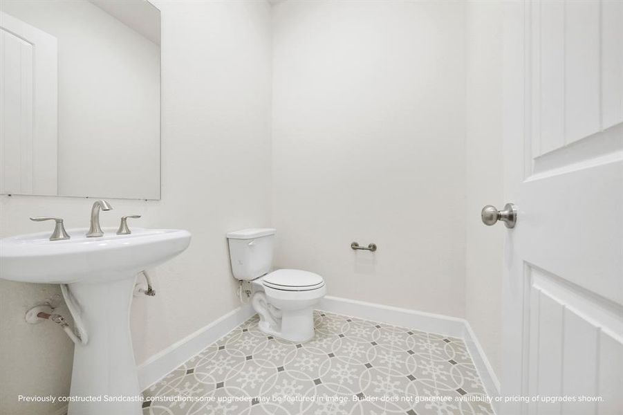 The discreet powder room off the foyer boasts classic finishes, including a stylish pedestal sink.