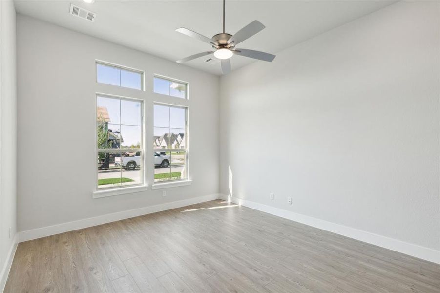 Empty room with ceiling fan and light wood-type flooring