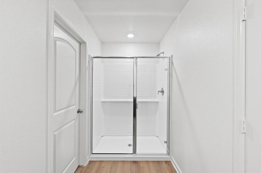 Bathroom with wood-style floors and a shower with shower door