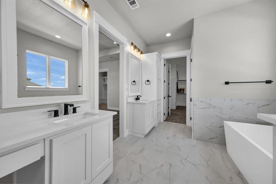 Bathroom featuring tile flooring, vanity, and a tub