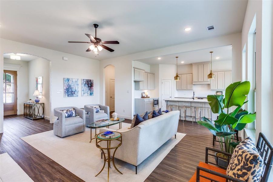 Living room with ceiling fan and dark hardwood / wood-style flooring