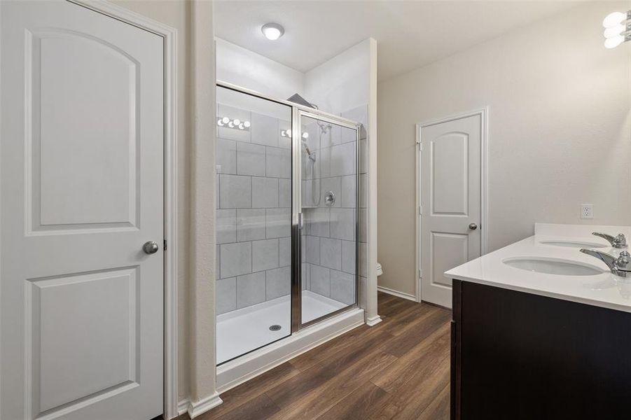 The primary bathroom boasts a dual vanity, walk in shower and large walk in closet.