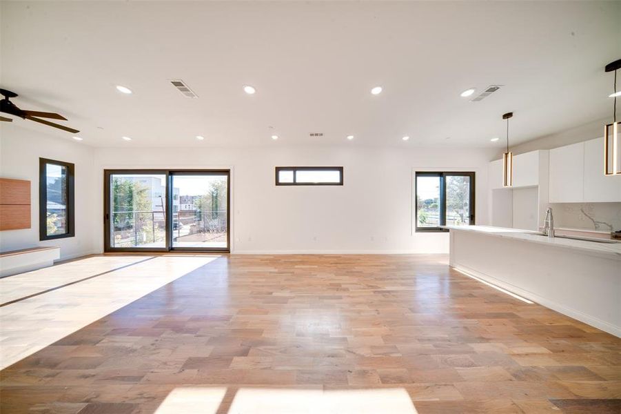 Unfurnished living room with ceiling fan and a healthy amount of sunlight