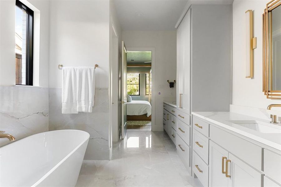 Bathroom featuring vanity, tile walls, and a bathtub