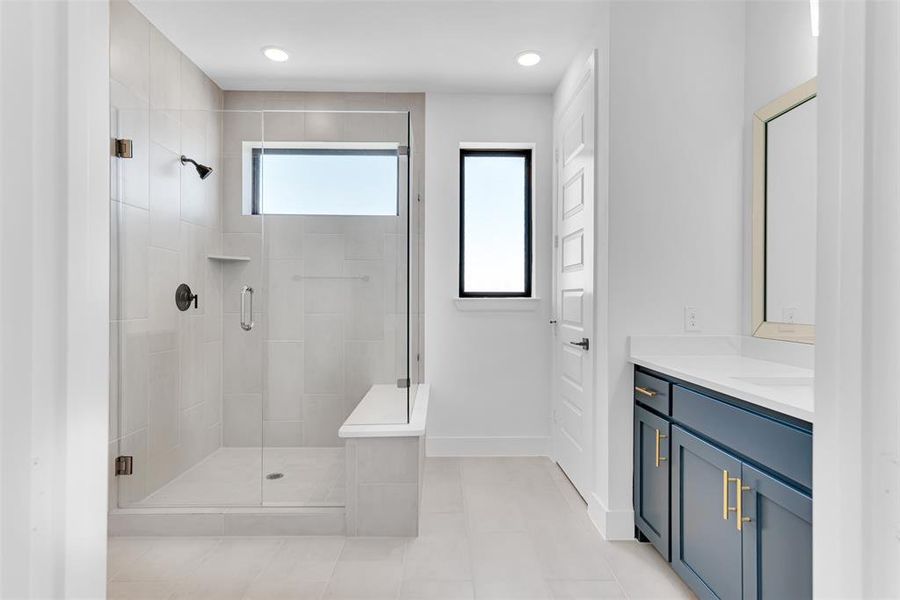 The primary suite bath is a dream come true with lots of natural light and an oversized shower with frameless glass, Big storage closet too!