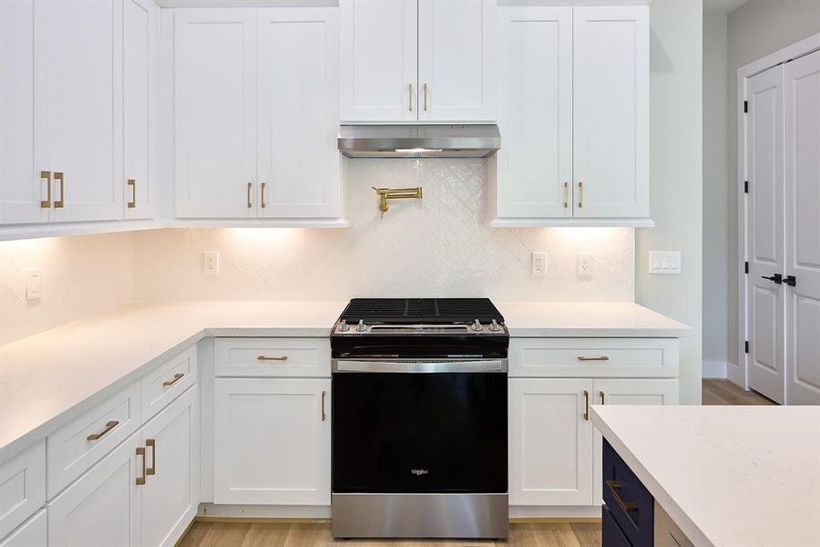 Quarts countertops, gold plated pot filler, and 42" cabinets adorn this luxurious kitchen.
