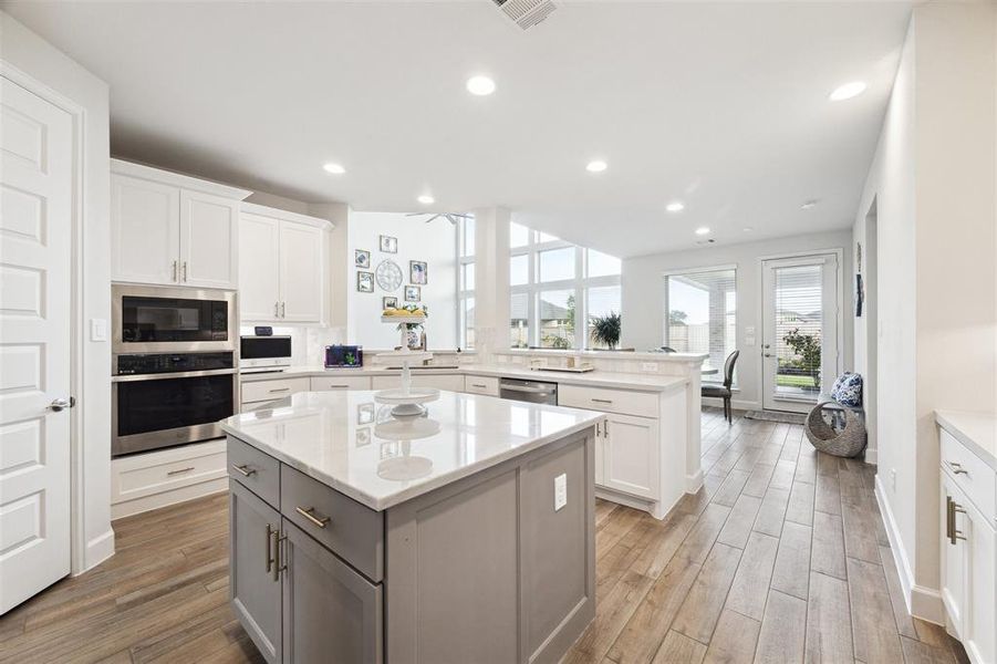 This view over the island is toward the breakfast area, and family room. This view also shows the built-in microwave and wall oven.