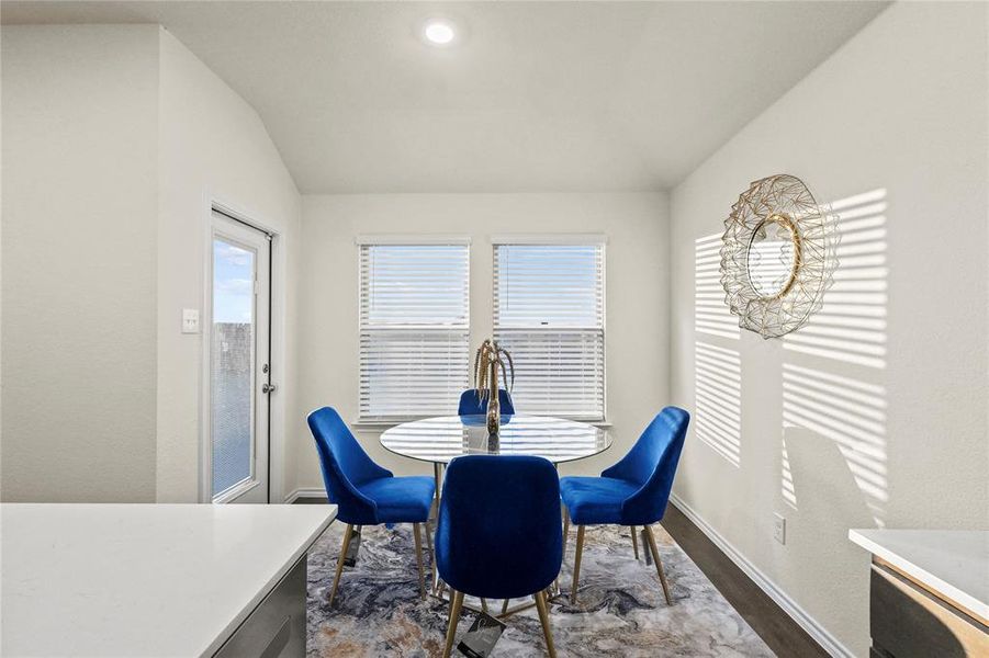 Dining space with high ceiling and wood-style flooring