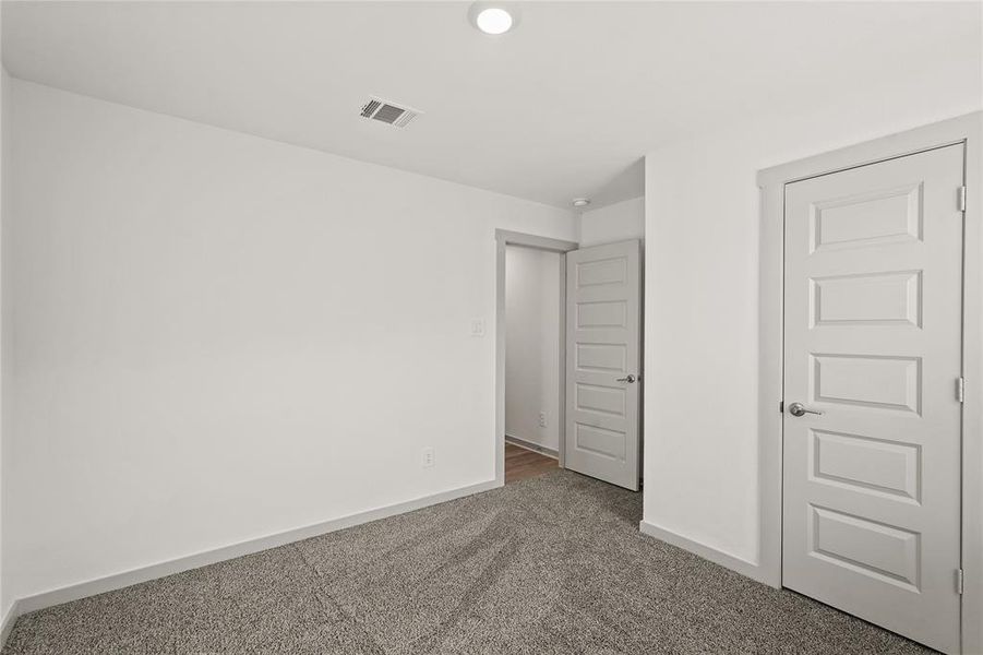 The third guest bedroom also enjoys plush carpeting and a large closet