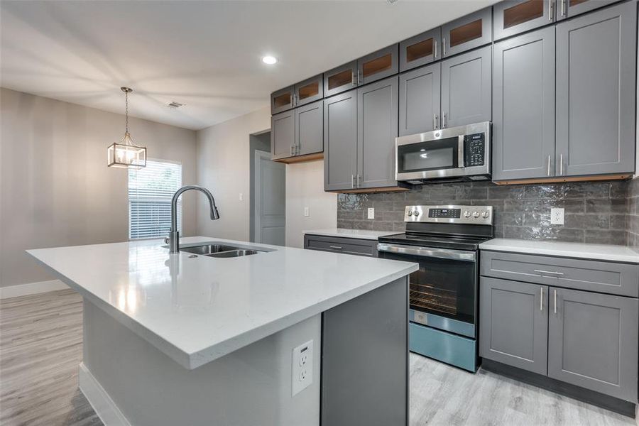 Kitchen features cabinets with hardware and decorative tile backsplash.