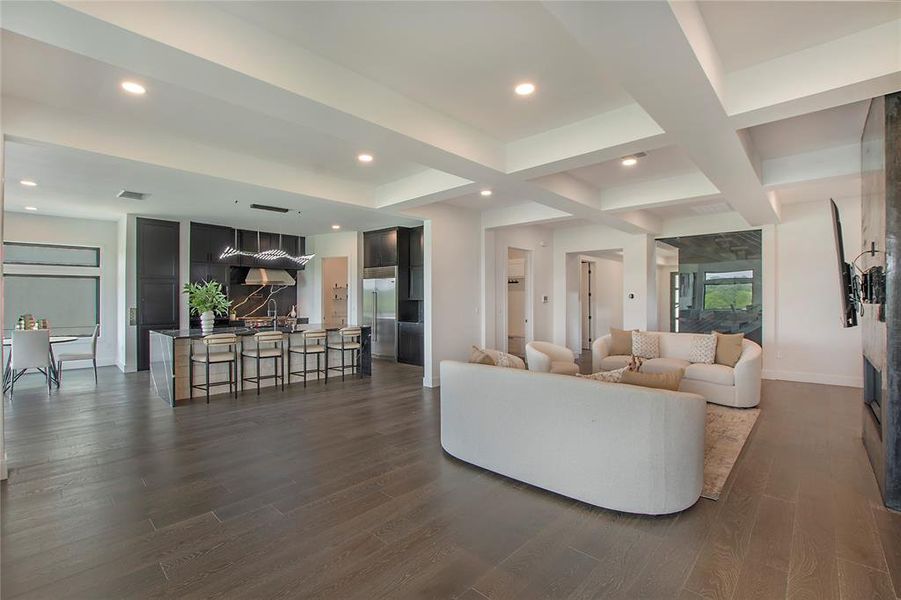 Living room featuring beamed ceiling, coffered ceiling, and dark hardwood / wood-style floors