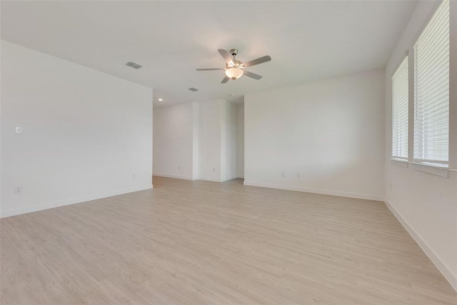 Unfurnished room with ceiling fan and light hardwood / wood-style flooring