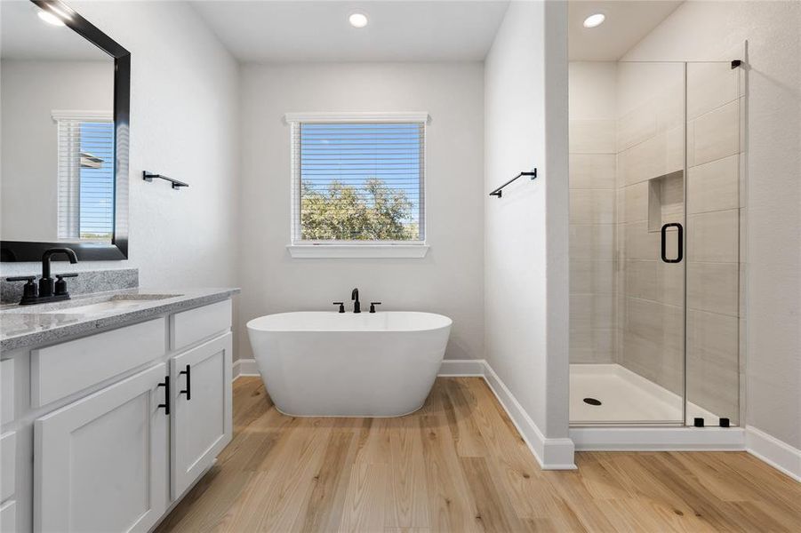Master bathroom includes granite countertop, elongated mirror, and dual-vanity sinks. Relax in the large soaking tub or enjoy the spacious, standing shower.
