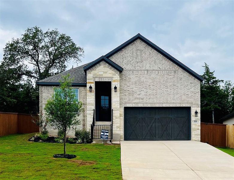 Our beautiful Kendall floor plan comes with a long driveway, a cedar garage door, and lush front yard landscaping.