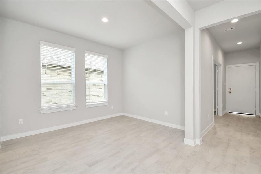 Create lasting memories with your family and friends at the dining table! This expansive dining room showcases sophisticated flooring, custom paint, and seamlessly connects to the family room and kitchen, providing an open and inviting atmosphere. Sample photo of completed home with similar floor plan. Actual colors and selections may vary.