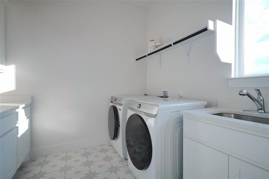 Spacious laundry with cabinets and sink.